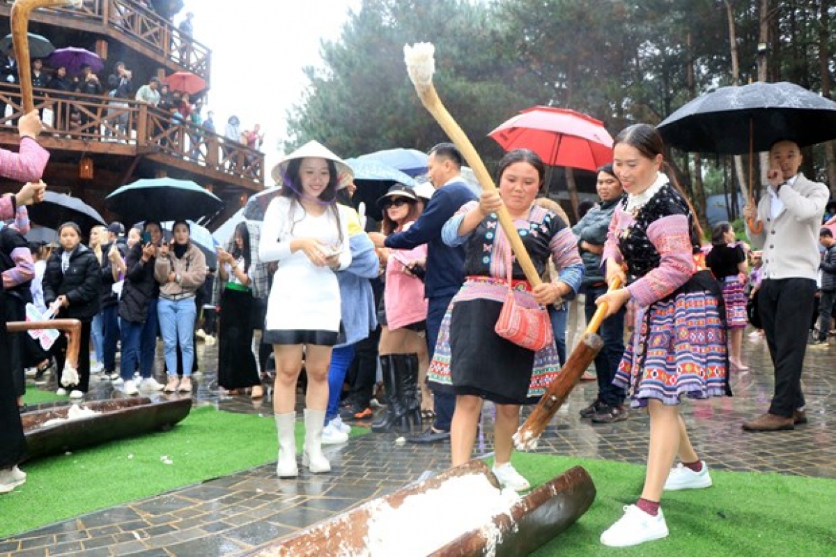 Du khách tham gia trải nghiệm hoạt động giã bánh dày của đồng bào dân tộc Mông tại huyện Vân Hồ. 