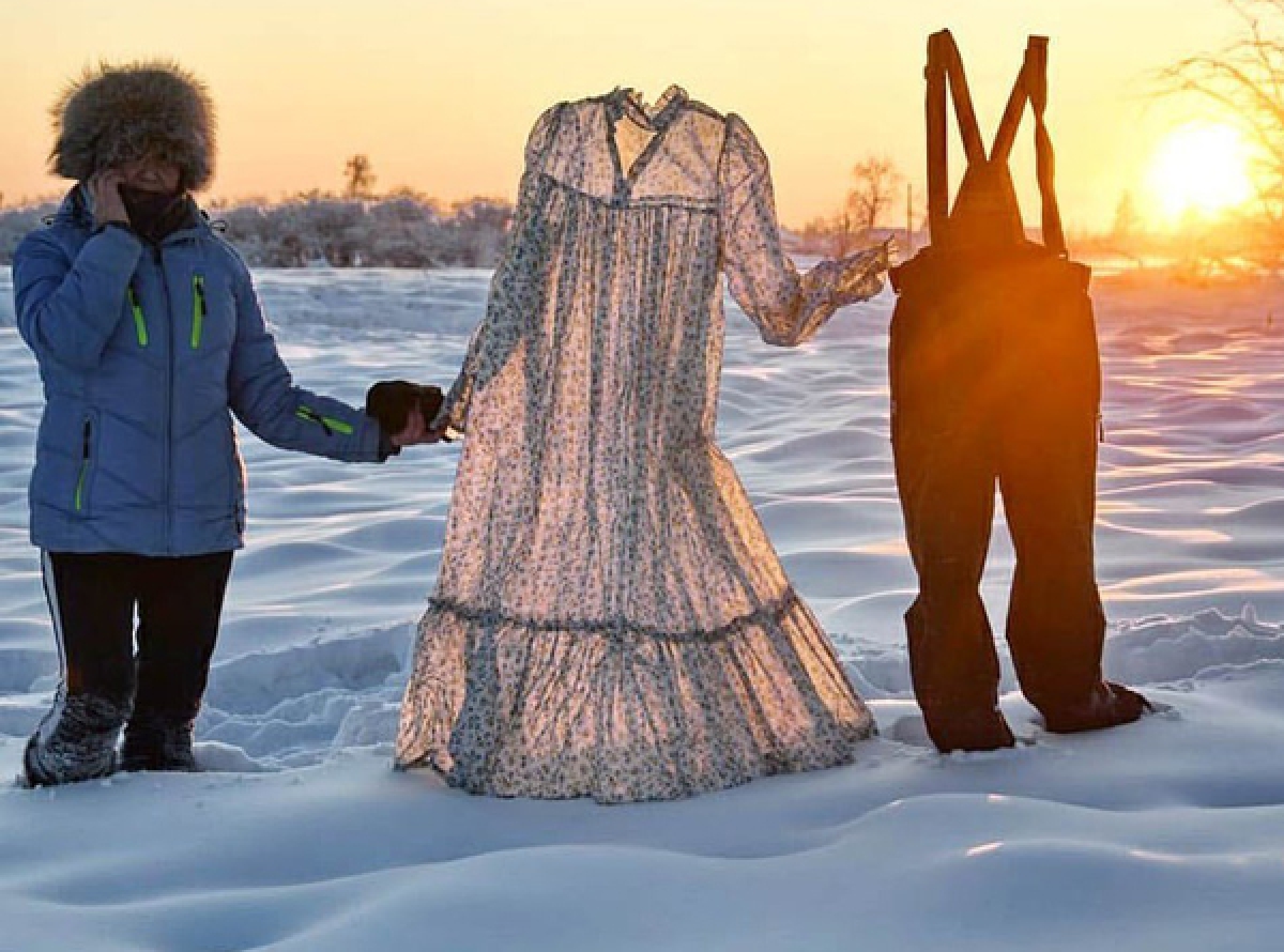 Galina Davydova, một cô giáo ở Yakutsk đang mang những bộ quần áo đóng băng của mình ra ngoài trời.     