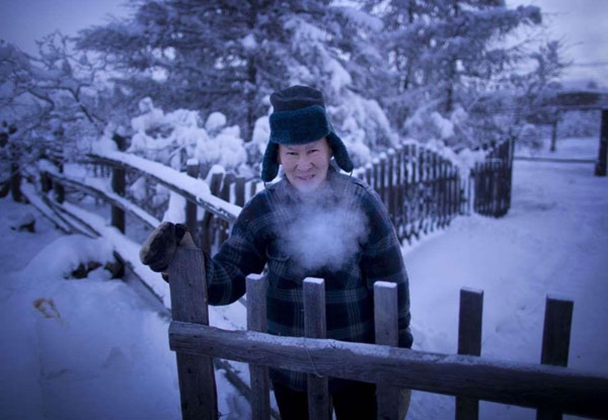 Alexander Platonov, một giáo viên đã nghỉ hưu, đang mở cổng bước ra ngoài con đường băng tuyết.