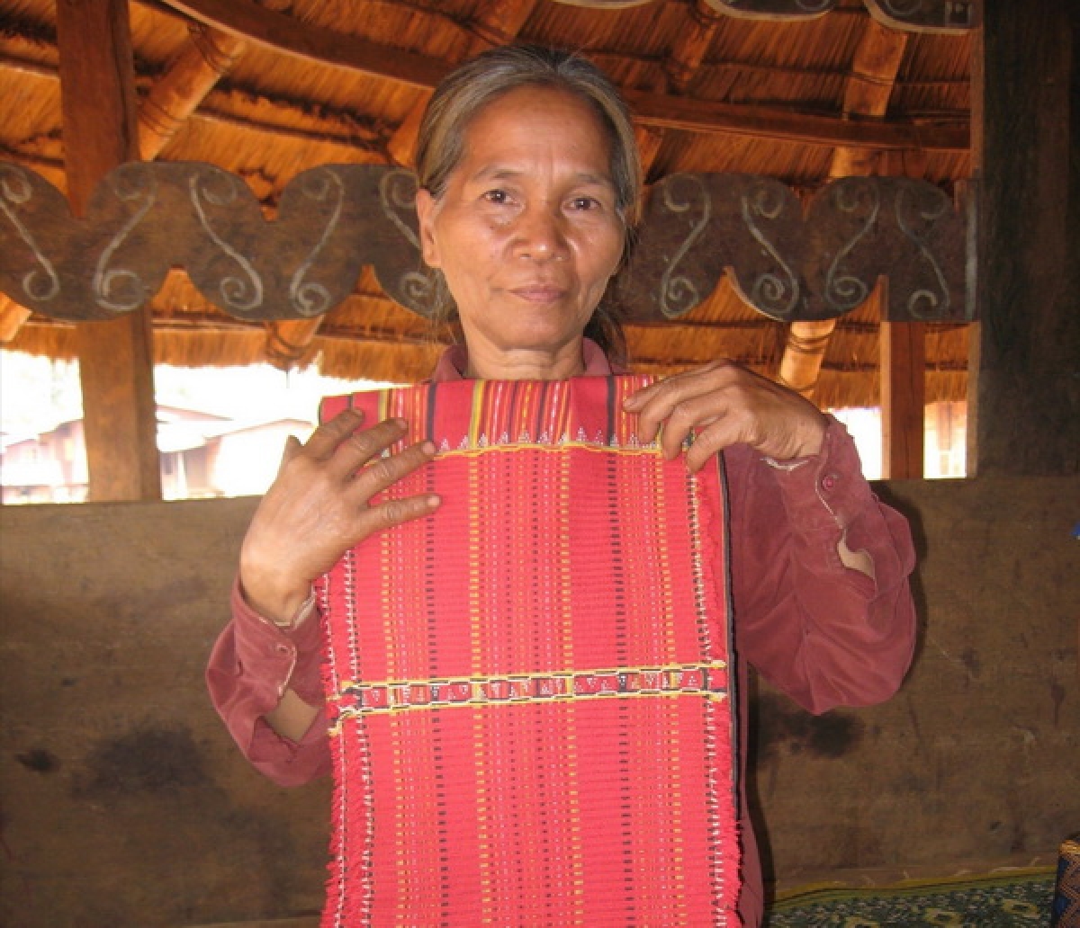 Thợ dệt thổ cẩm người Cơtu ở huyện Thông Vai, tỉnh Salavan với sản phẩm vừa hoàn thành (Ảnh: Linda Susan)