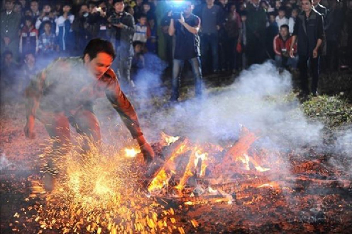 Sau khi được thầy cúng làm lễ, người thanh niên nhảy bật lên bằng cả hai chân và lao vào giữa đống lửa cháy rừng rực mà không bị bỏng. Ảnh: Minh Đức- TTXVN