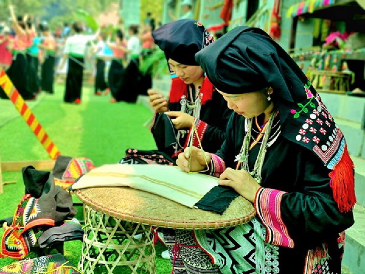 Phụ nữ dân tộc Dao giới thiệu nghệ thuật in vải và thêu thổ cẩm. Ảnh: Hoàng Tâm