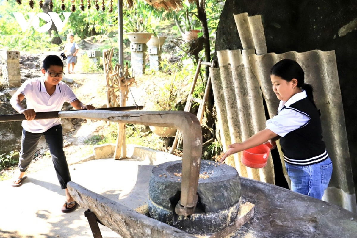 Du khách thích thú trải nghiệm việc xay ngô để làm mèn mén - món ăn truyền thống của đồng bào Mông địa phương