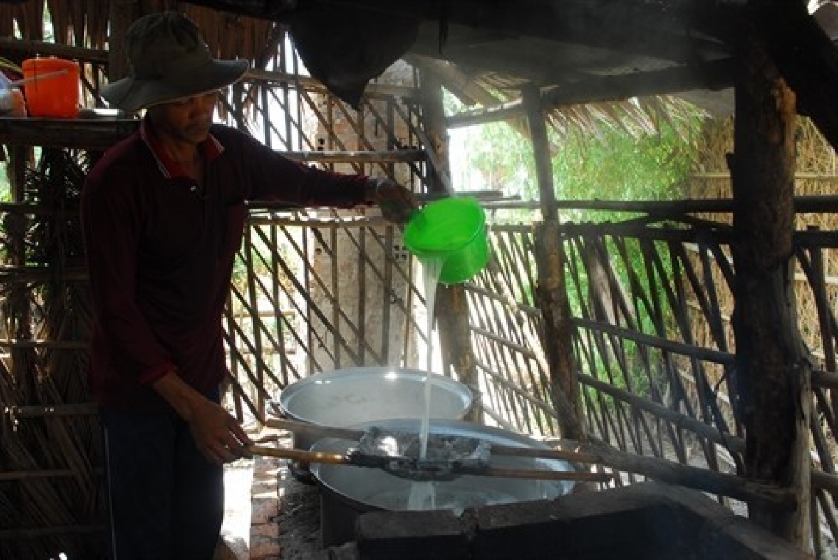 Công đoạn vớt bỏ bọt trong khâu làm đường thốt nốt của đồng bào dân tộc Khmer An Giang. Ảnh: Mạnh Linh-TTXVN