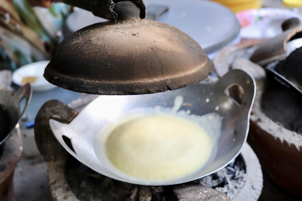 Bánh bò Thốt nốt nướng trên bếp lửa than đậy bằng nắp đất nung. Ảnh: Thanh Sang – TTXVN