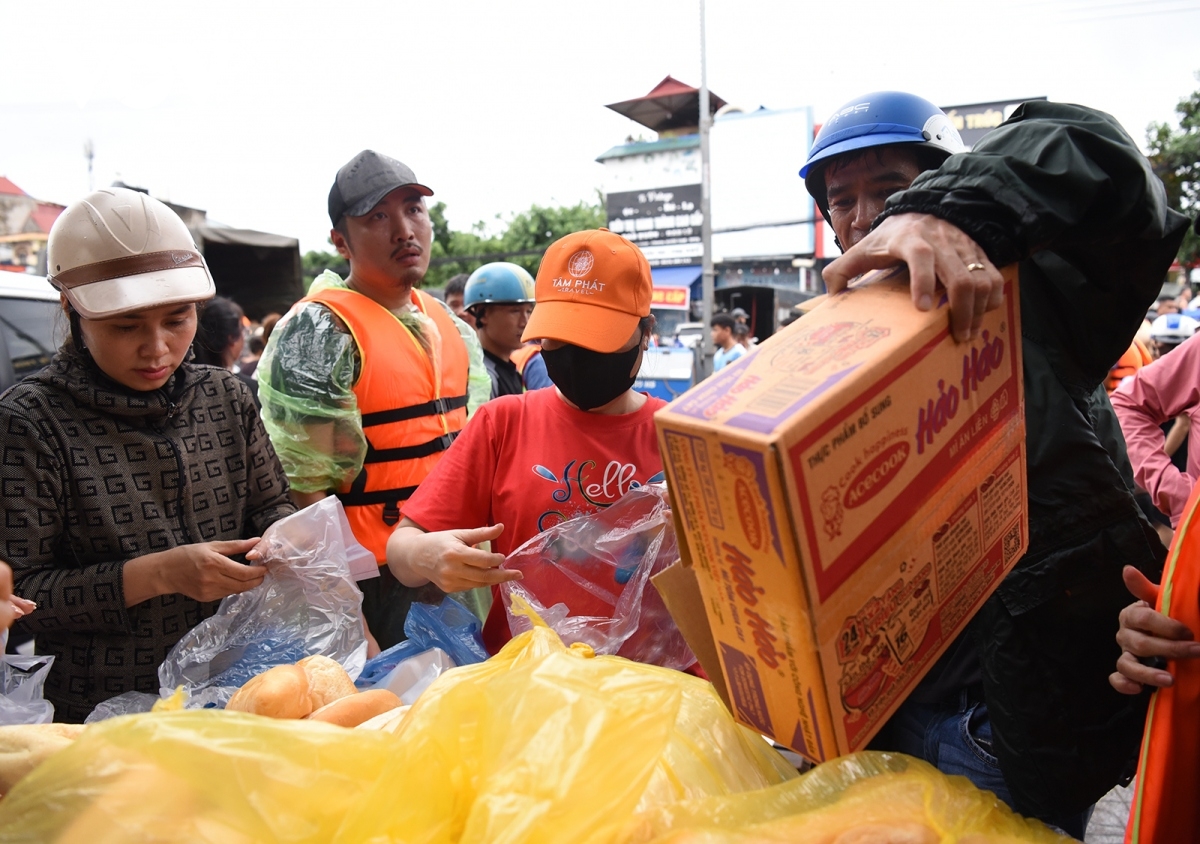 Nhiều tổ chức, cá nhân mang theo đồ thiết yếu đến các điểm ngập lụt để hỗ trợ người dân.