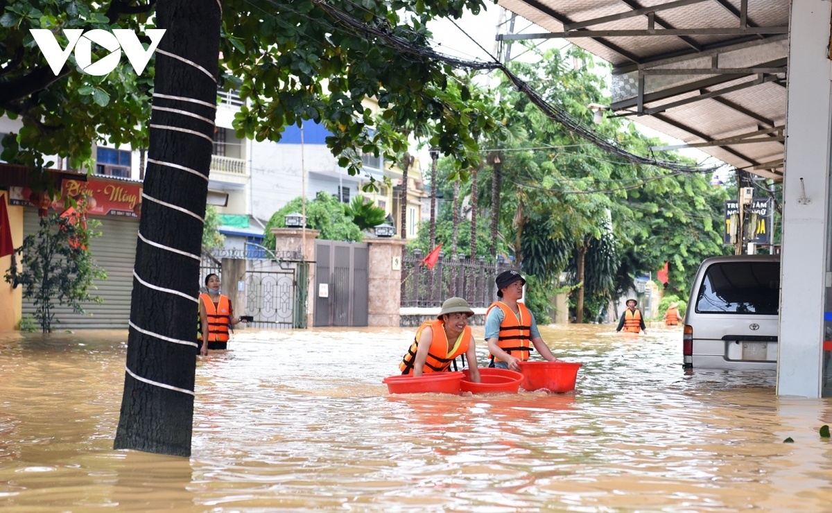 Tại một số điểm nước nông hơn, nhiều tình nguyện viên, người dân tự lội nước để chuyển nhu yếu phẩm cho các hộ gia đình.