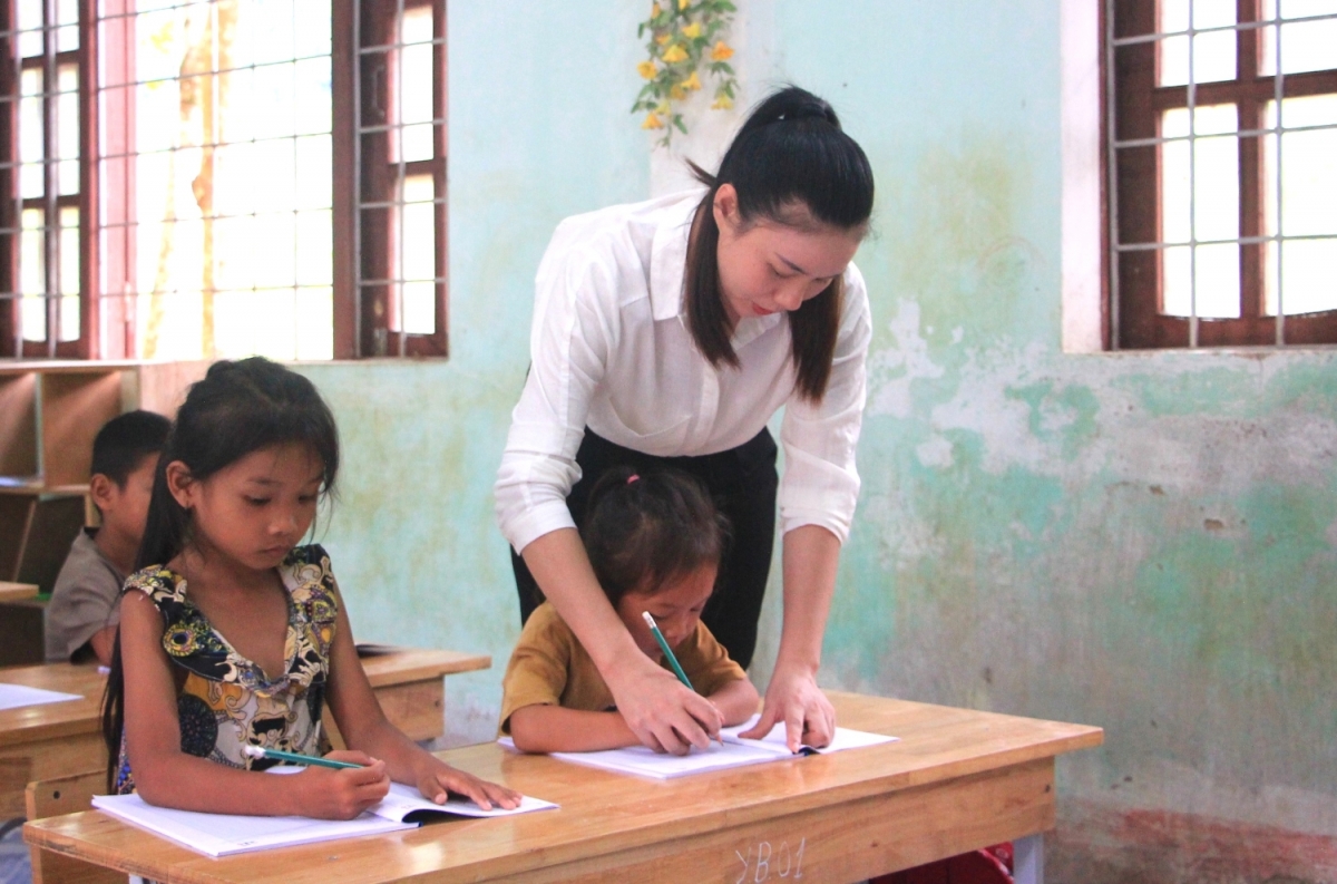 Giáo viên Trường Tiểu học và Trung học cơ sở Thượng Hóa hướng dẫn từng nét chữ cho học sinh lớp 1