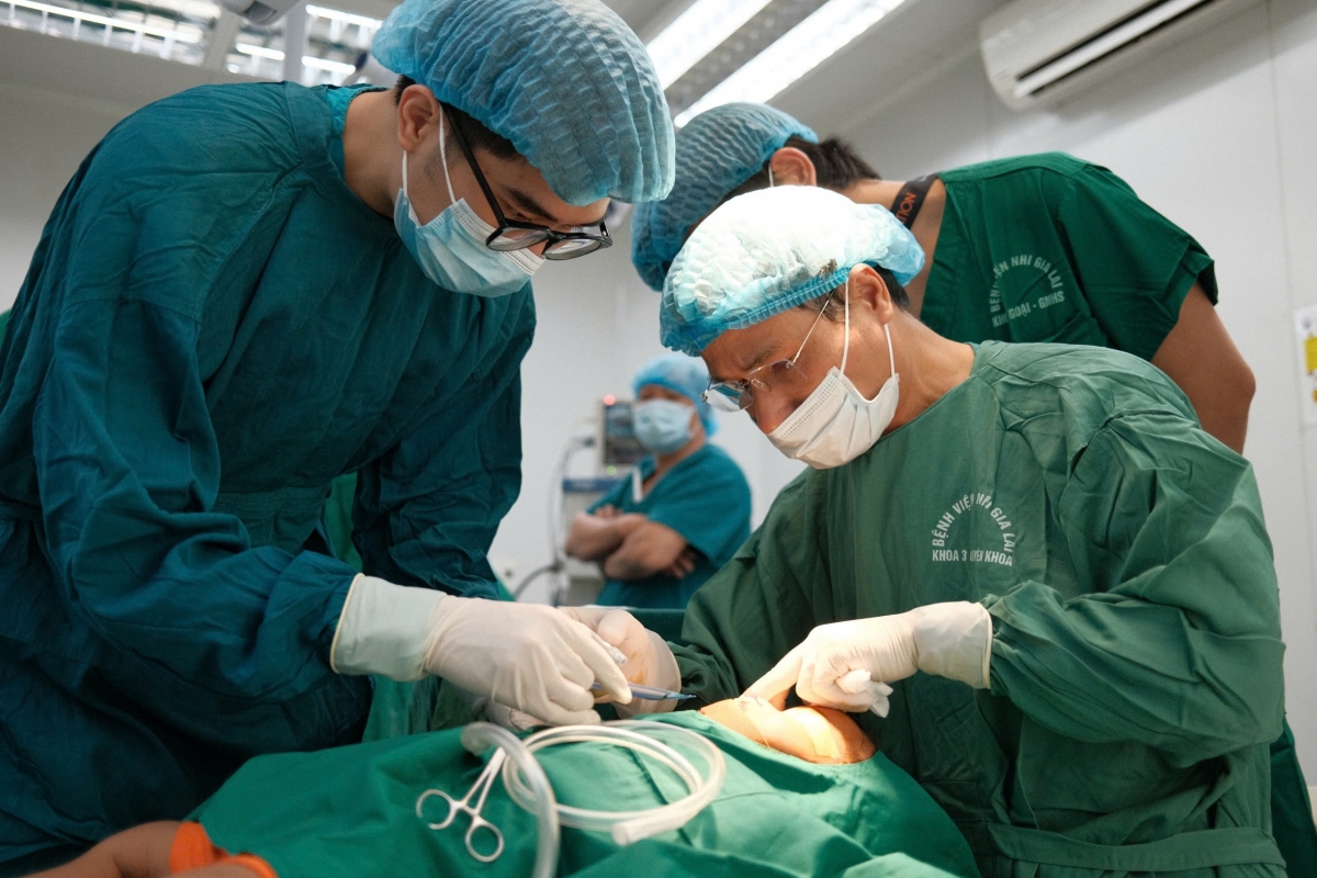 Thạc sĩ, Bác sĩ Bạch Minh Tiến, Trưởng khoa Phẫu thuật Tạo hình và Thẩm mỹ, Bệnh viện Hữu nghị Việt Nam – Cuba, trưởng đoàn y tế (người đeo kính trong) trực tiếp phẫu thuật trong toàn đợt. (ảnh: Nguyễn Thảo)
