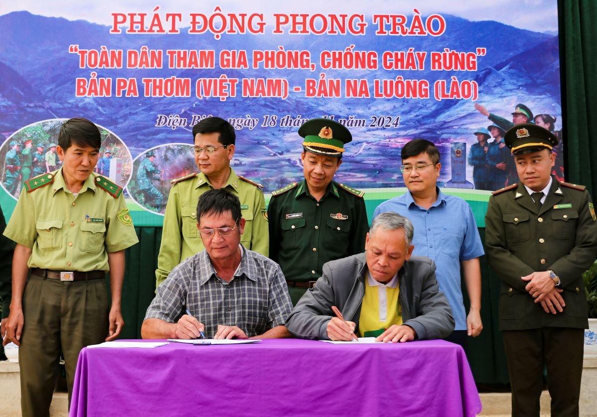 Người dân bản Pa Thơm (Việt Nam) và Na Luông (Lào) ký cam kết phòng chống cháy rừng.