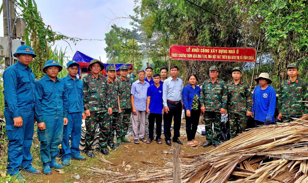 Cán bộ chiến sĩ, chính quyền địa phương, đoàn thanh niên chụp ảnh lưu niệm
cùng hộ dân được hỗ trợ nhà ở trong ngày khởi công