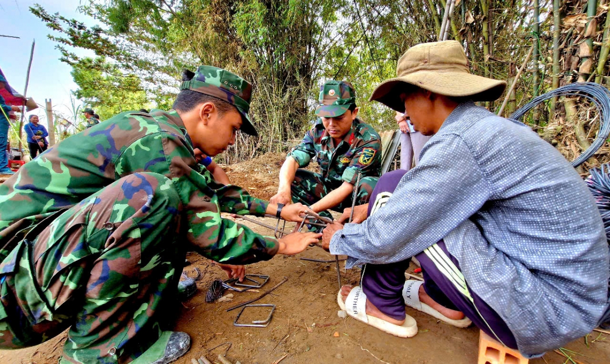 Cán bộ, chiến sĩ tham gia cùng thợ nối buộc thép cột xây nhà