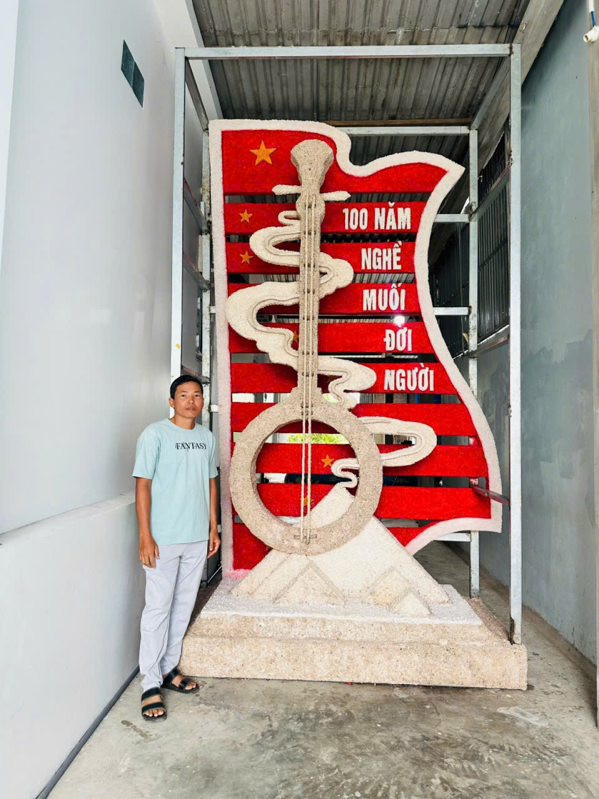 Ông Hồ Chí Ân bên cây đờn kìm cách điệu làm từ những hạt muối sắp hoàn thành