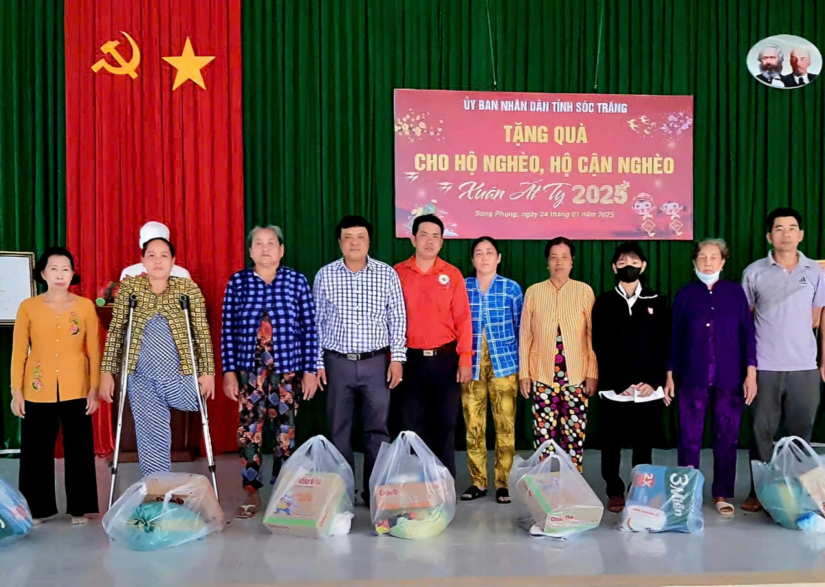 Ông Nguyễn Hữu Đức (người mặc áo đỏ) trao tặng quà cho các hoàn cảnh khó khăn